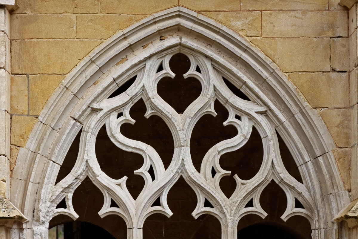 Remplage de pierre en gothique flamboyant dans une galerie du cloître de Cadouin